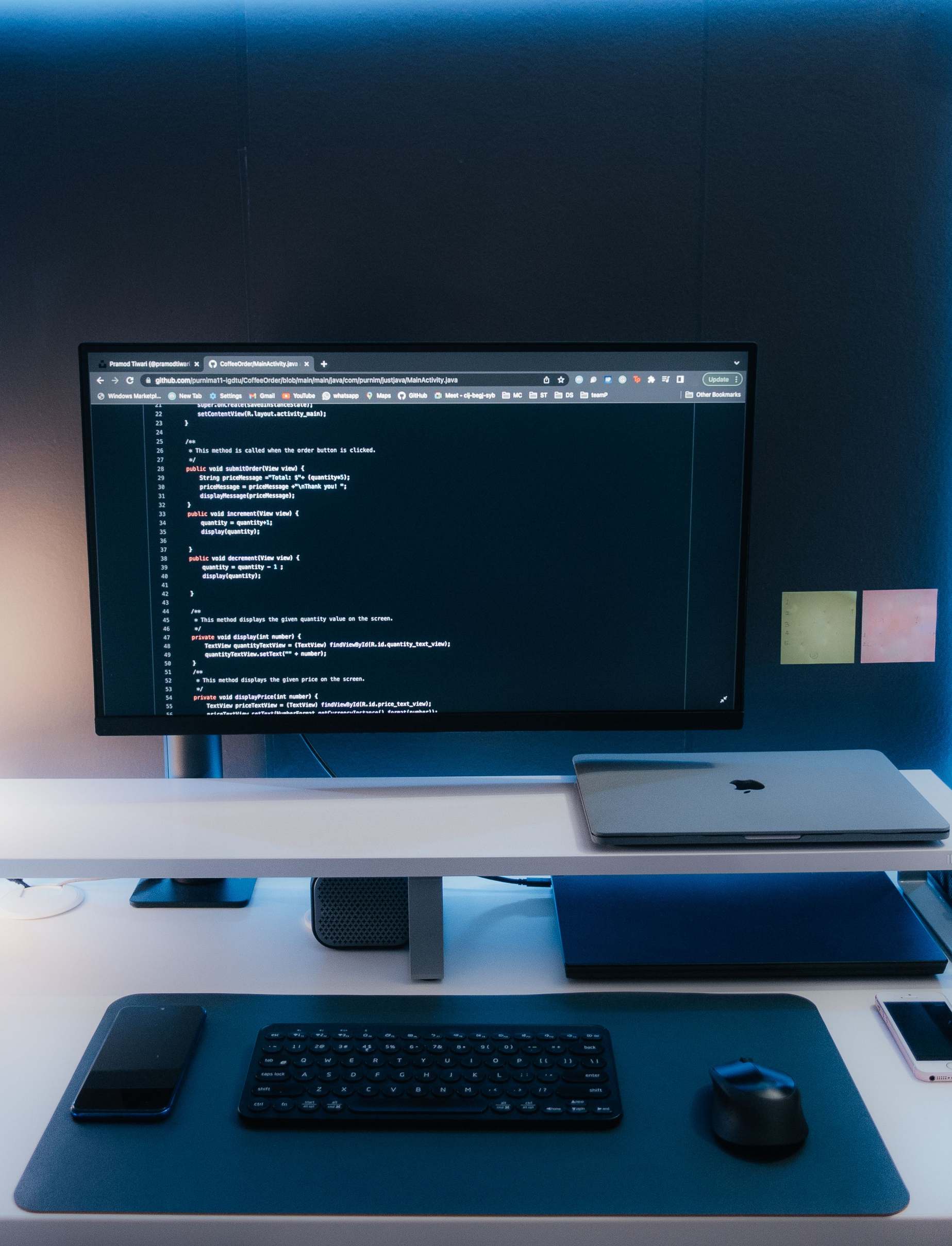 Wide view of an office desk with computer equipment and a large monitor